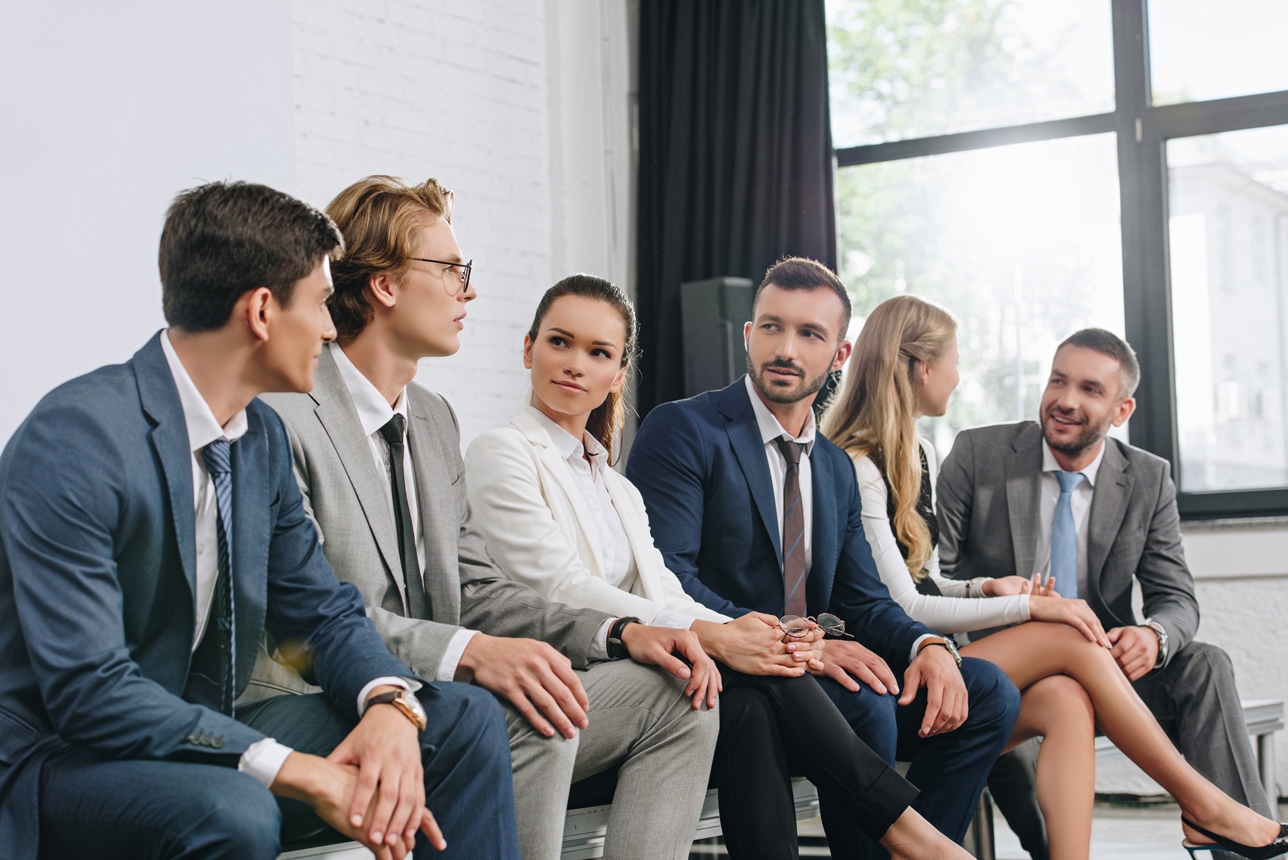 businesspeople sitting on chairs in row during training in hub